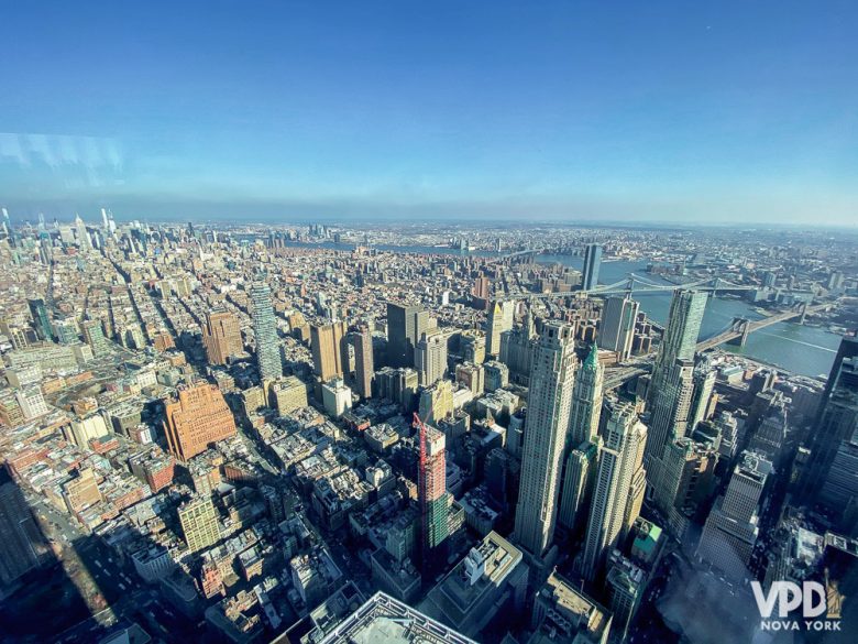 Foto da cidade de Nova York vista de cima, com o céu azul ao fundo 