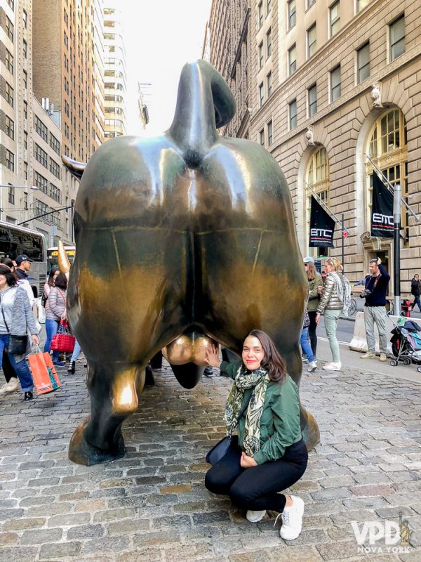 Foto da Bia embaixo do famoso touro de Wall Street em um tour pelo Financial District