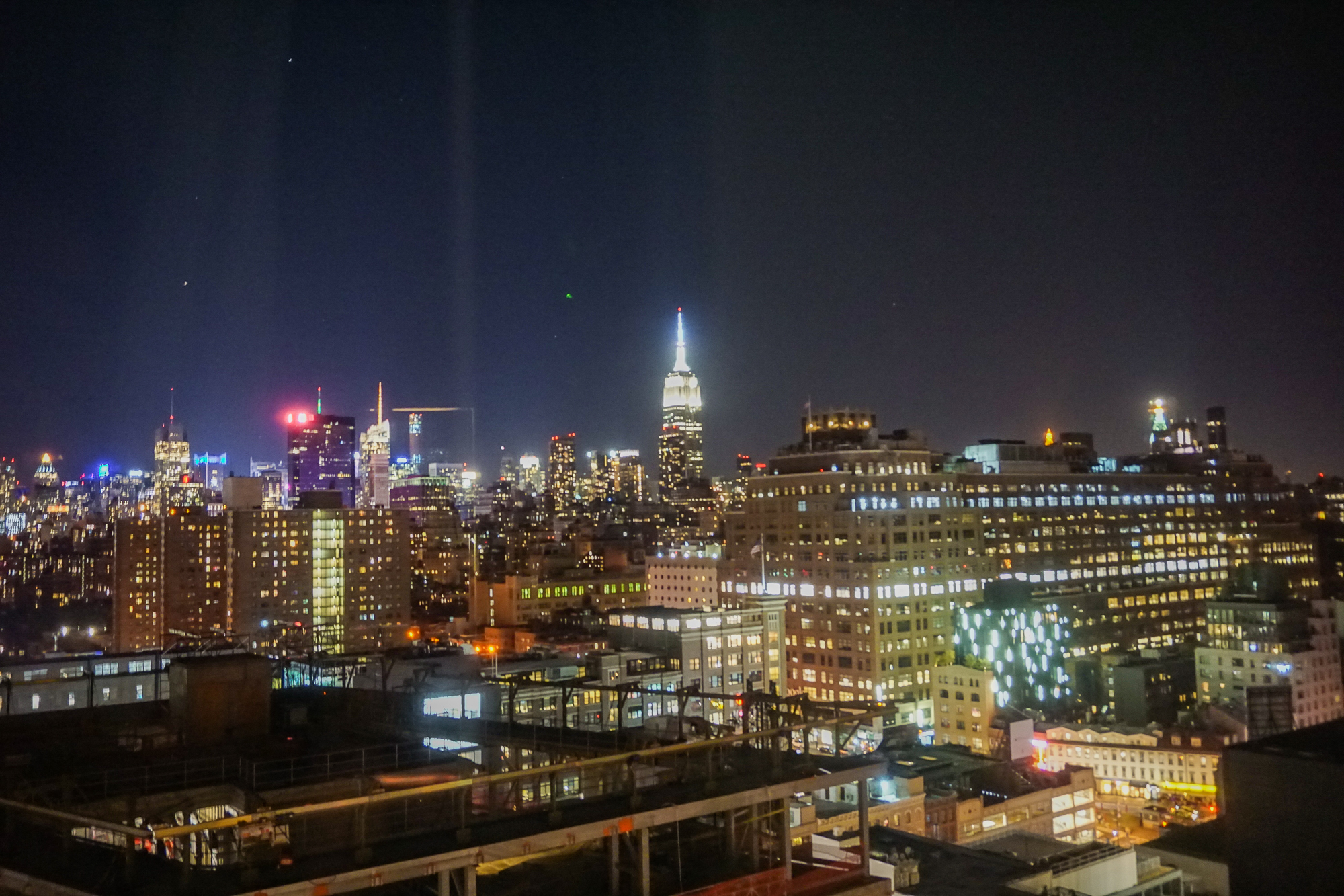 Foto da cidade de Nova York iluminada à noite, com o céu escuro ao fundo