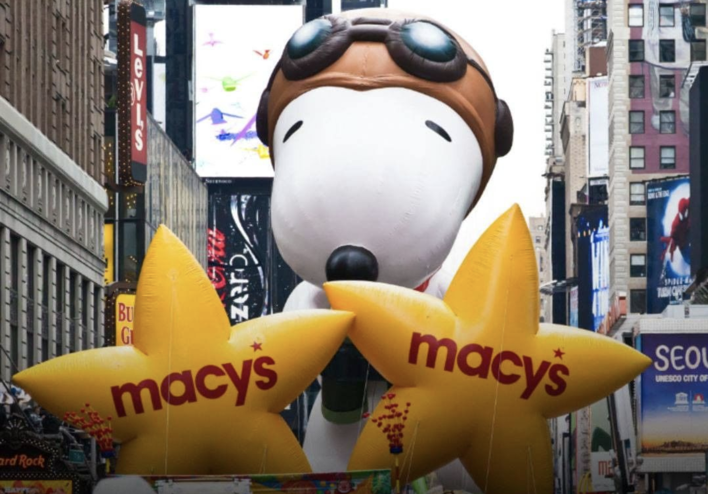 Foto de um balão gigante do Snoopy com óculos de aviador durante a tradicional parada de Ação de Graças da Macy's