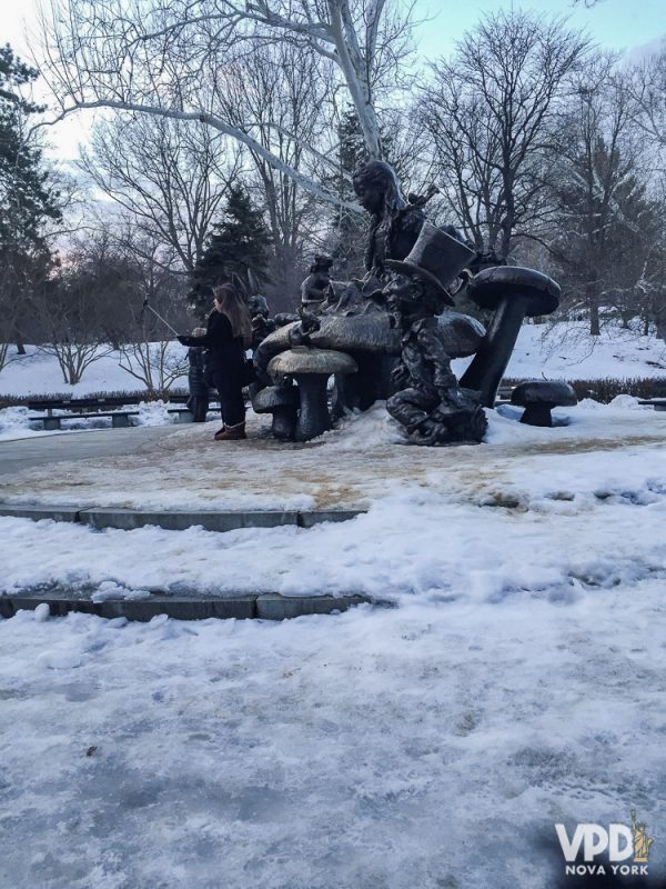 Foto da estátua da Alice no País das Maravilhas no Central Park com neve acumulada em cima e ao redor 
