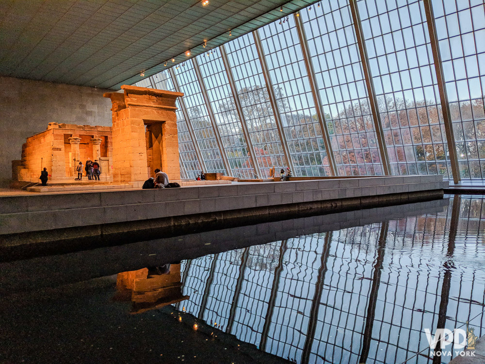 Foto do interior de um museu em Nova York, com amplas janelas de vidro.