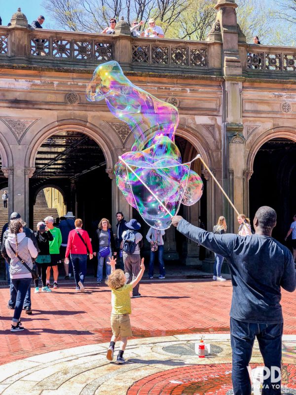 Foto de uma criança brincando com bolhas de sabão no Central Park 