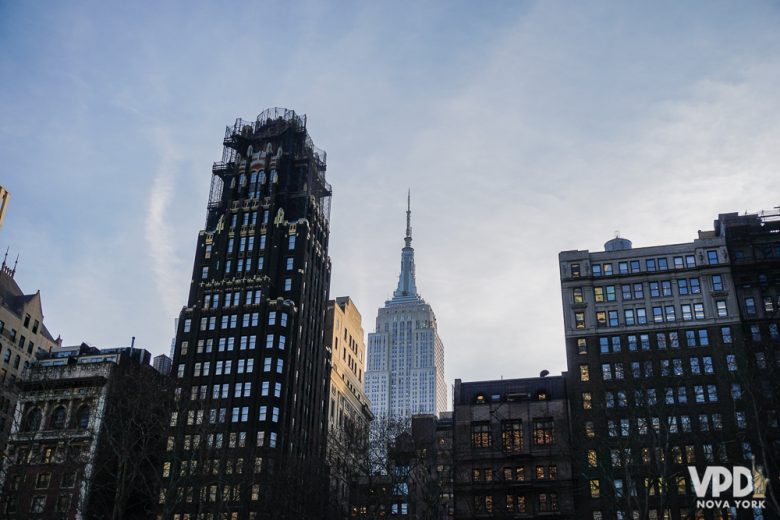 O Empire State Building visto de fora, com o céu claro ao fundo