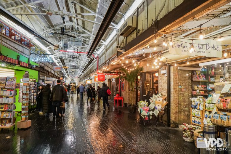 Foto do Chelsea Market, com estabelecimentos dos dois lados e iluminação de Natal 