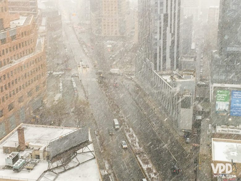 Foto de Nova York no mês de março com bastante neve caindo na rua.