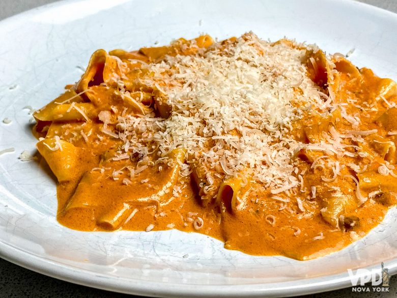 o pappardelle alla fiesolana do bar pitti feito em casa pronto. ele está em um prato branco e coberto com queijo parmesão ralado.