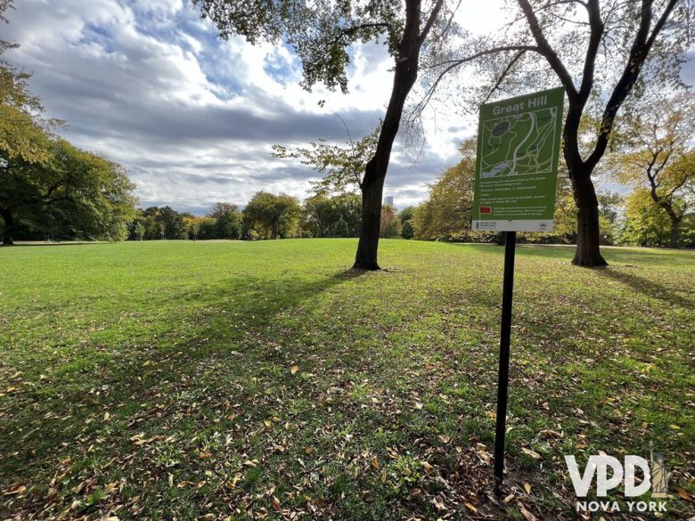 foto de um grande gramado com uma placa verde com texto em verde dizendo Great Hill.