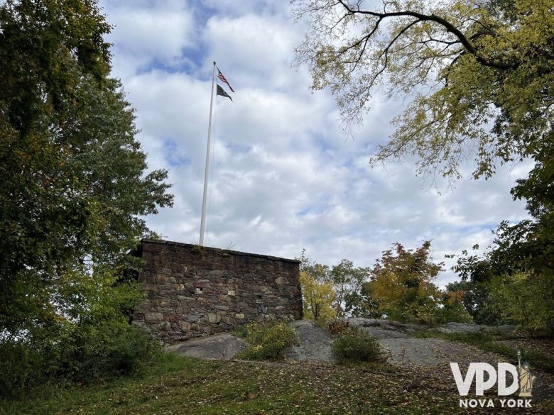 foto de um forte dentro do central park. ele traz uma bandeira americana no topo