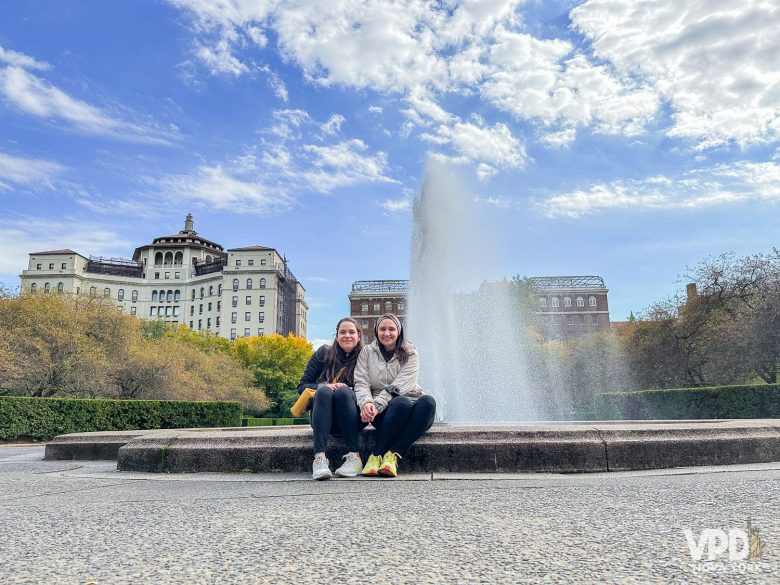 Foto da Bia e da Re sentadas em frente a uma fonte do Central Park.